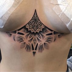 a woman's stomach with an intricate tattoo design on the side, and her lower back