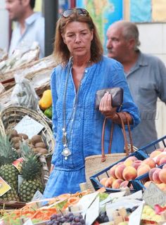 a woman is walking through an outdoor market