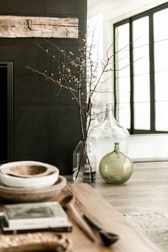 a living room filled with furniture and a fire place covered in vases on top of a wooden table