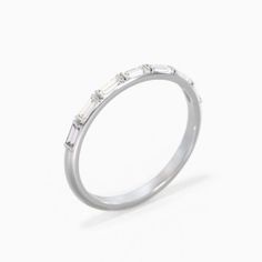 a white gold ring with three baguettes on the side, set in 18k white gold