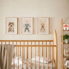 a baby's crib with three pictures hanging on the wall