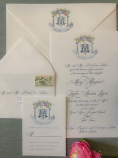 the wedding stationery is set up on top of an envelope, with a pink rose