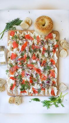 an assortment of food on a cutting board next to some bread and other foodstuffs