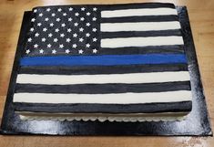 a cake decorated with an american flag and the thin blue line is on a wooden table