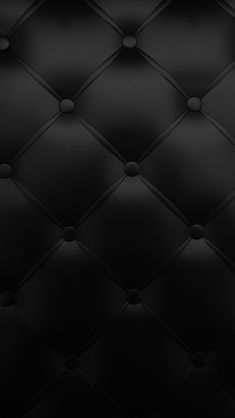 black leather upholstered wallpaper with round holes in the middle and dark background