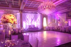 a dance floor with chandeliers and flowers on it at a wedding or other function