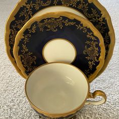 a set of black and gold dishes on the floor