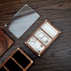 three different types of jewelry sitting on top of a wooden table next to each other