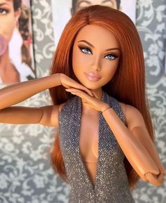 a close up of a barbie doll with red hair wearing a silver dress and posing for the camera