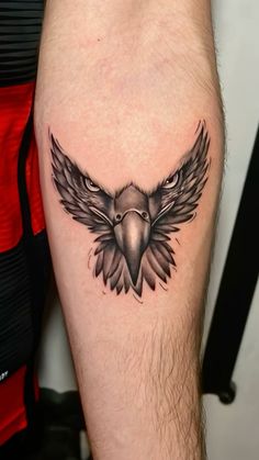 a tattoo on the leg of a man with an eagle head and wings tattooed on it