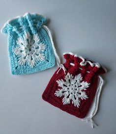 two crocheted bags sitting next to each other on a white surface with one bag in the shape of a snowflake