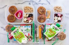 two plastic containers filled with food on top of a marble countertop next to some snacks