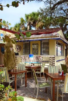 an outdoor dining area with tables, chairs and a sign that says salty dines