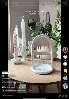 a table topped with lots of jewelry on top of it's display shelf next to a potted plant