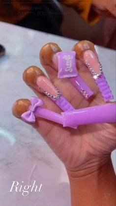 a person holding up some fake nails with bows on them