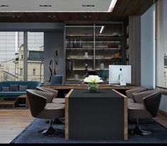 an office with two chairs and a table in front of the desk is surrounded by large bookshelves