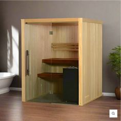 an empty sauna in a bathroom with a tub and toilet behind the glass door