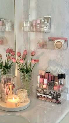 a bathroom counter topped with pink flowers and candles