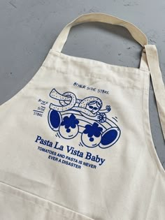 a white apron with a blue logo on it that says pasta la vista baby, tomorrow is always a snacker