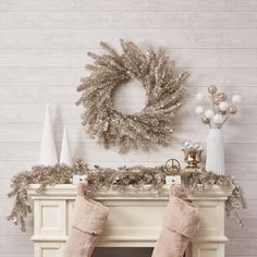 a fireplace with stockings hanging from it's sides and a wreath on the mantle