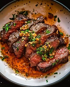 a white plate topped with steak covered in sauce and garnished with parsley