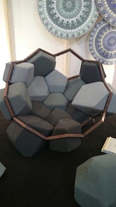 an unusual looking chair in the middle of a room with blue and gray cushions on it