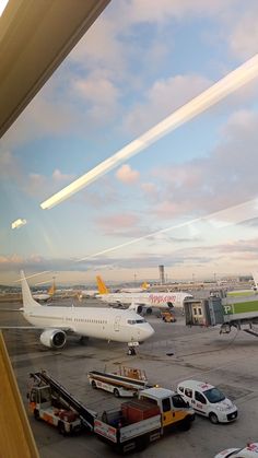 an airport filled with lots of cars and planes on the tarmac at sunset or dawn