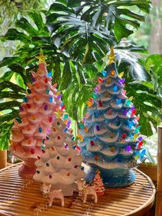 three ceramic christmas trees sitting on top of a table