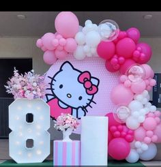 a hello kitty balloon arch with balloons and flowers in front of the letters'b '