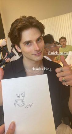 a young man holding up a piece of paper with the words thank king written on it