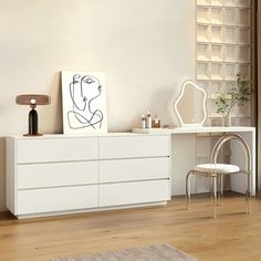 a white dresser sitting in a living room next to a mirror and table with a painting on it