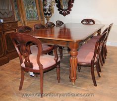 a dining room table and chairs with pink upholstered cushions