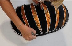 a woman is holding onto a black and gold purse