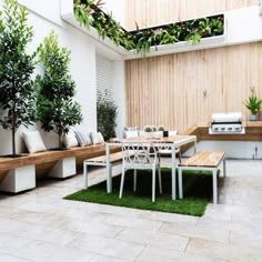 an outdoor dining area with potted trees and benches