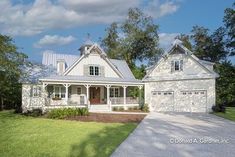 a large white house with two garages on the front and one story attached to it