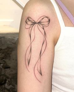 a woman's arm with a bow tattoo on it