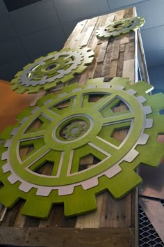 some green and white gears are on top of a wooden board that is being worked on