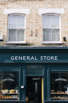 a store front with lots of bread and pastries on display in it's windows