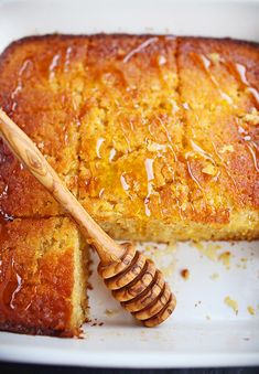 a close up of a cake on a plate with a wooden spoon