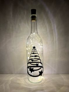 a glass bottle with a christmas tree in it