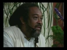 a man with dreadlocks sitting in front of a potted plant and looking off into the distance