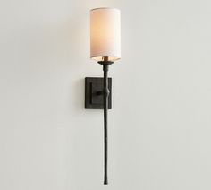 a wall light with a white shade on it's side and a black arm