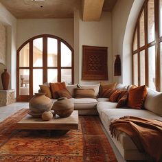 a living room filled with lots of furniture and large arched windows in the wall behind it