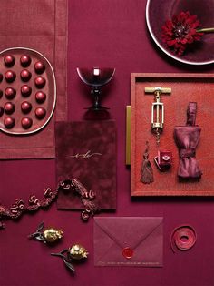 a table topped with lots of different items on top of a purple surface next to a plate