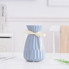 a blue vase sitting on top of a white table