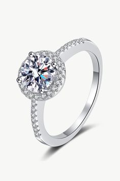 a white gold ring with diamonds on the sides and a center stone in the middle