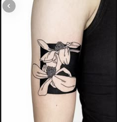 a black and white flower tattoo on the left arm