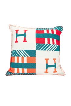 an orange and blue pillow with the letter h on it