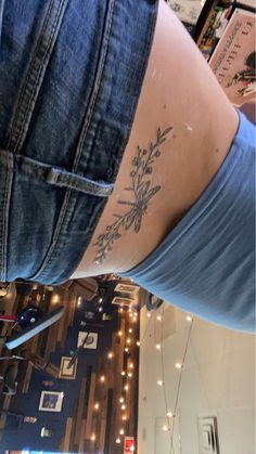 a woman with a flower tattoo on her lower back