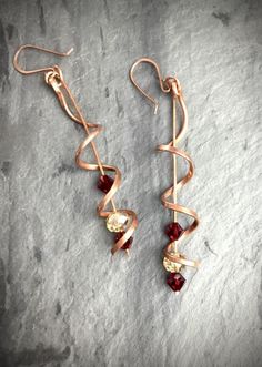 Handmade with reclaimed copper and Swarovski Crystal Beads, the corkscrew design pairs with the ruby and topaz colored Swarovski crystal beads to create earrings that are fun yet refined. The perfect look for any party, these earrings are sure to get lots of attention! While long and dramatic these earrings are lightweight and comfortable to wear.Click through to get yours today! #spiralearrings, #corkscrewearrings,  ##handmadeearrings, #copperearrings, #swarovskiearrings Copper Wire Earrings Handmade, Copper Wire Dangle Earrings As Gift, Unique Dangle Copper Wire Jewelry, Elegant Copper Wire Earrings, Spiral Copper Wire Earrings As Gift, Wire Wrapped Copper Spiral Earrings, Topaz Color, Swarovski Crystal Beads, Beaded Dangle Earrings